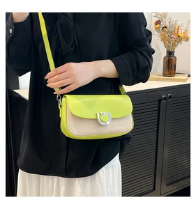 Détail du sac bandoulière avec rabat en cuir jaune et texture tissée beige