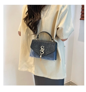 Dettaglio della patta glitterata e corpo in PVC blu con trama trapuntata della borsa