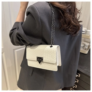 Close-up of white woven leather rectangular bag with black metal clasp and chain strap