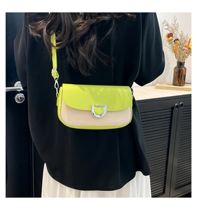 Détail du sac à bandoulière en cuir vert néon et tissu tissé beige avec boucle en argent