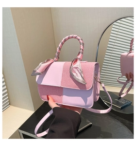 Detailed shot of pink leather tote bag with striped stitching and scarf handle