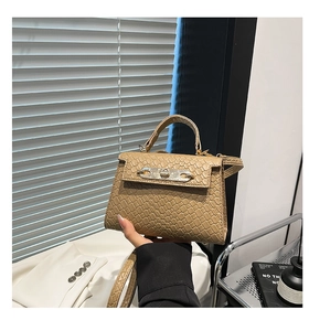 Macro detail of camel woven leather texture and metal lock on mini Kelly style bag