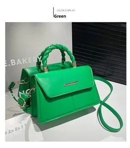 Détail du sac à bandoulière en cuir vert émeraude avec poignée tressée et accents dorés