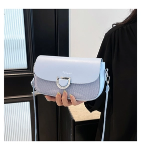 Détail du sac bandoulière bleu clair avec tissu rayé et boucle en D argentée