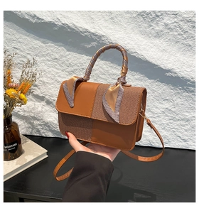 Brown patchwork handbag with textured fabric, silk scarf handle, and crossbody strap
