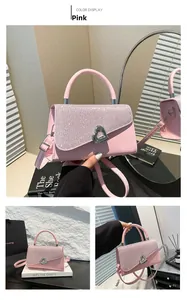 Détail du sac bandoulière rose à paillettes avec boucle coeur et poignée chic