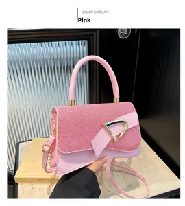 Pink shoulder bag detail showing textured fabric lid and golden D-shaped buckle