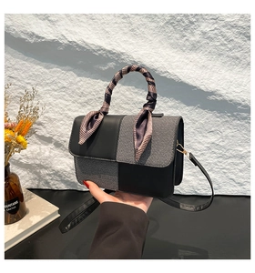 Detail of color-block handbag with gray fabric panels and silk scarf wrapped handle
