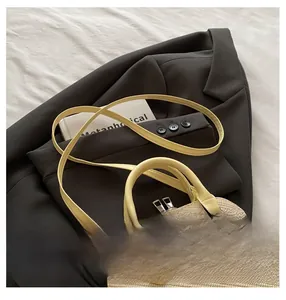 Top-down view of beige straw shell bag with yellow leather handles and double zip detail