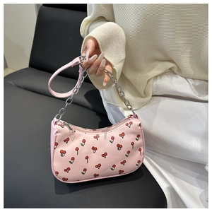 Détail du sac bandoulière rose avec motifs cerises et bandoulière en métal rose
