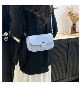 Détail du sac à bandoulière bleu clair avec boucle en D argentée et mesh rayé