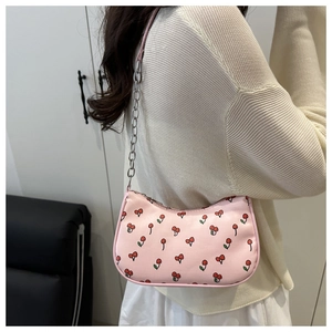 Détail du sac porté épaule rose avec motif cerise et bandoulière en chaîne argentée