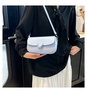 Détail d'un sac bandoulière bleu clair avec texture tissée et boucle argentée en D