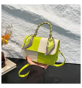 Detail of color-block square bag with silk scarf wrapped handle and canvas texture