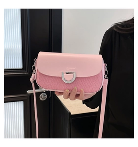 Détail du sac à bandoulière rose avec tissu rayé et boucle en D argentée élégante