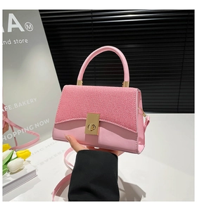 Close-up of pink crossbody bag with woven flap detail and golden metallic buckle