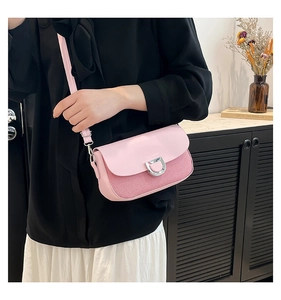 Détail du sac bandoulière rose en patchwork avec cuir lisse et boucle argentée en forme de D