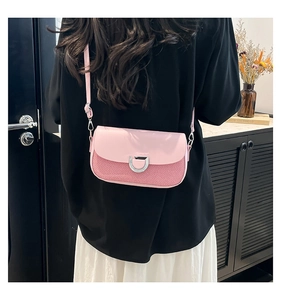 Détail du sac à bandoulière rose avec texture tressée, boucle en D et fine lanière