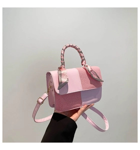 Detail of pink patchwork crossbody bag with textured fabric and silk scarf handle