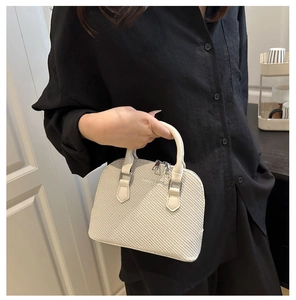 Close-up of cream woven texture shell bag with FASHION & BAGS metal logo and zipper
