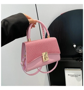 Detail view of pink contrast texture handbag with elegant gold clasp and handle