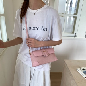 Model showing a pink crossbody bag with mesh patchwork and gold buckle closure