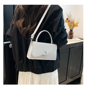 Détail du sac à main argenté à paillettes avec fermoir cœur en métal et fini miroir
