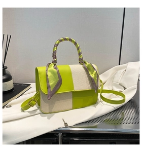 Detail of green leather and beige fabric patchwork handbag with silk scarf handle