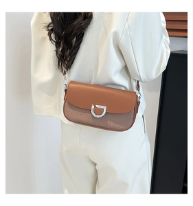 Mannequin portant un sac en cuir marron et toile avec une boucle en D argentée