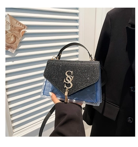 Détail du sac bandoulière en PVC bleu transparent avec rabat noir et logo doré SS