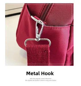 Detail of premium silver metal hook and red woven nylon strap on a women's shoulder bag
