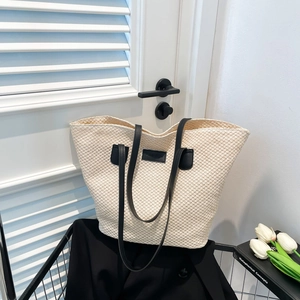 Sac fourre-tout chic en paille beige avec lanières noires et détail carré pour l'été