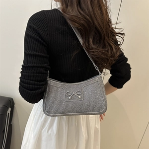 Sac sous le bras à paillettes argentées avec nœud métallique porté par un mannequin