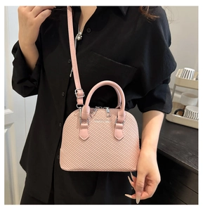 Pink woven shell bag with dual handles and Fashion & Bags text shown on a model