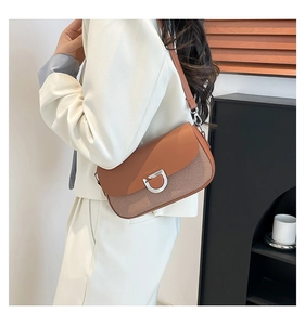 Vue détaillée du sac porté épaule marron tressé avec boucle fer à cheval sur modèle
