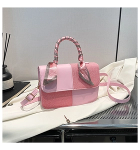 Detail of pink crossbody bag with patchwork fabric textures and silk scarf handle