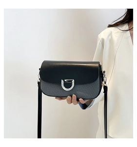Détail d'un sac bandoulière bicolore chic avec boucle argentée et texture de tissu