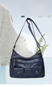 Detail of navy blue multi-pocket crossbody bag with soft faux leather and zip compartments