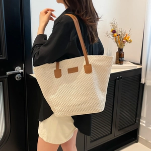 Sac seau tissé japonais avec bretelles en cuir marron porté par un mannequin
