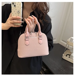 Pink woven texture shell bag with silver fashion logo shown in a lifestyle mirror selfie