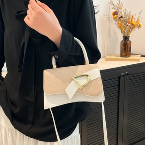Detail of white leather and beige woven flap bag with golden D-shaped metal buckle