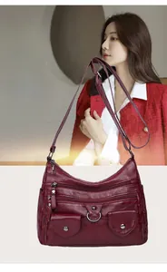 Close-up of wine red faux leather crossbody bag with multiple functional zipper pockets