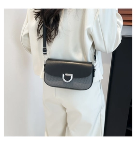 Détail du sac bandoulière tendance en patchwork de sergé gris et cuir noir élégant