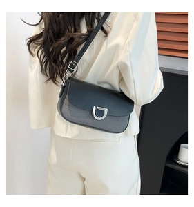 Détail du sac à bandoulière avec boucle D argentée sur tissu gris et cuir noir élégant