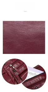 Detail showing high-quality leather texture and glossy zipper on burgundy crossbody bag