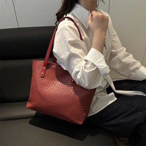 Chic red tote bag with intricate woven texture shown in a modern lifestyle setting