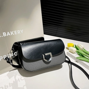 Détail du sac bandoulière en tissu gris et cuir noir avec boucle fer à cheval argentée