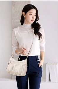 Detail of cream multi-layer faux leather shoulder bag with woven texture and silver zippers