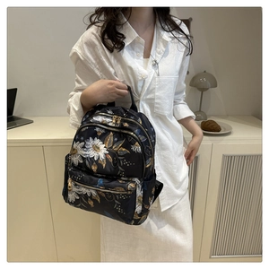 Close-up of durable butterfly floral print backpack with golden zippers in casual setting