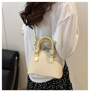 Close-up of beige woven texture handbag with FASHION & BAGS print and metal zipper